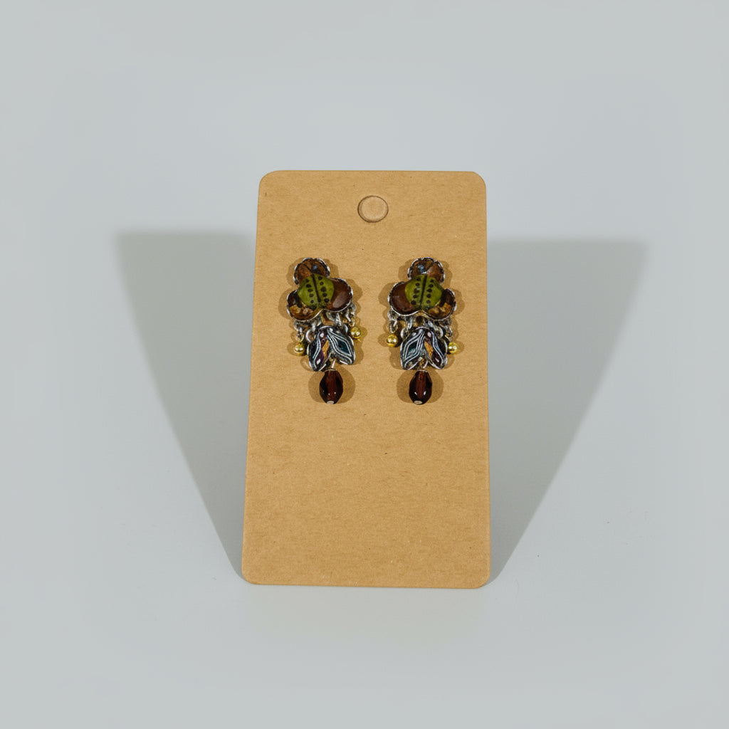 Pair of earrings on a cardboard backing with a textured white background